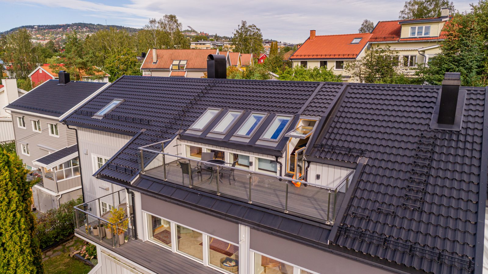 Påbygg med takvinduer og terrasser, fra drone. Samme hus som B8