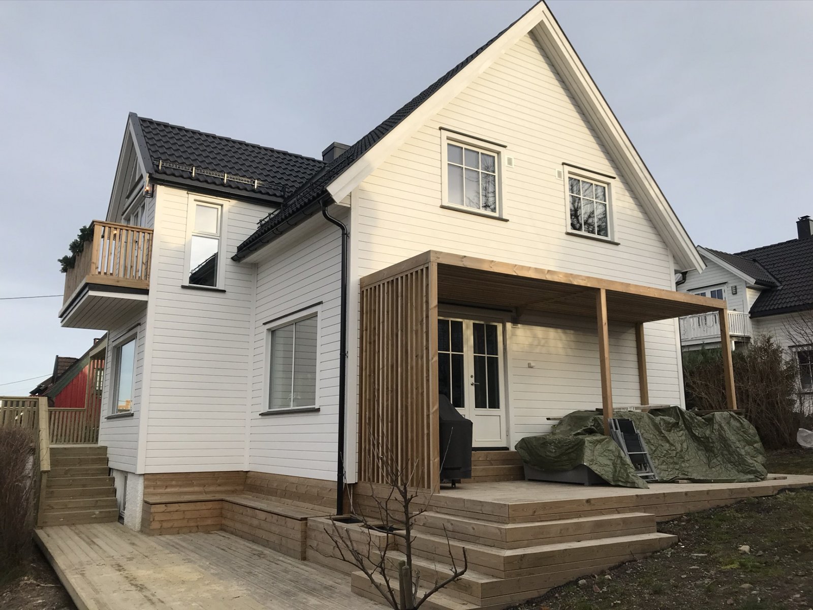 Hvitt hus med påbygg og ny terrasse (mobilbilde). Samme prosjekt som B16